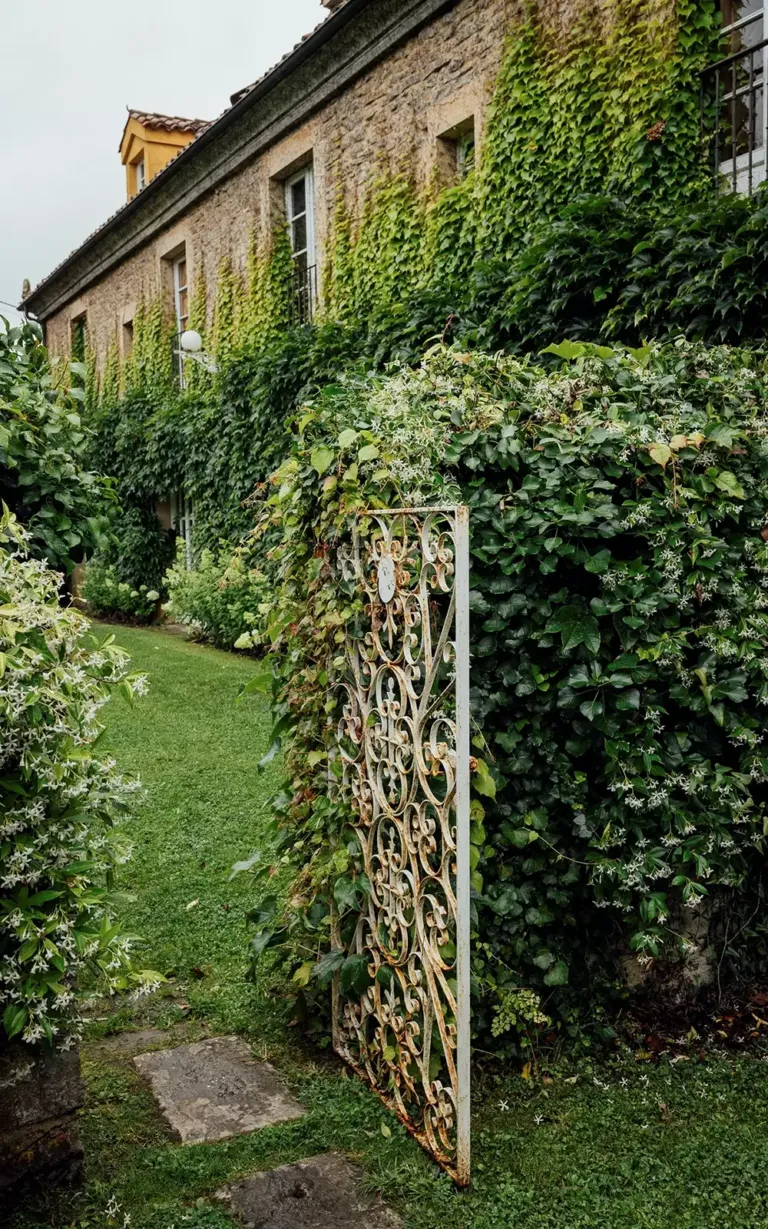 Puerta metálica que da acceso a un jardín